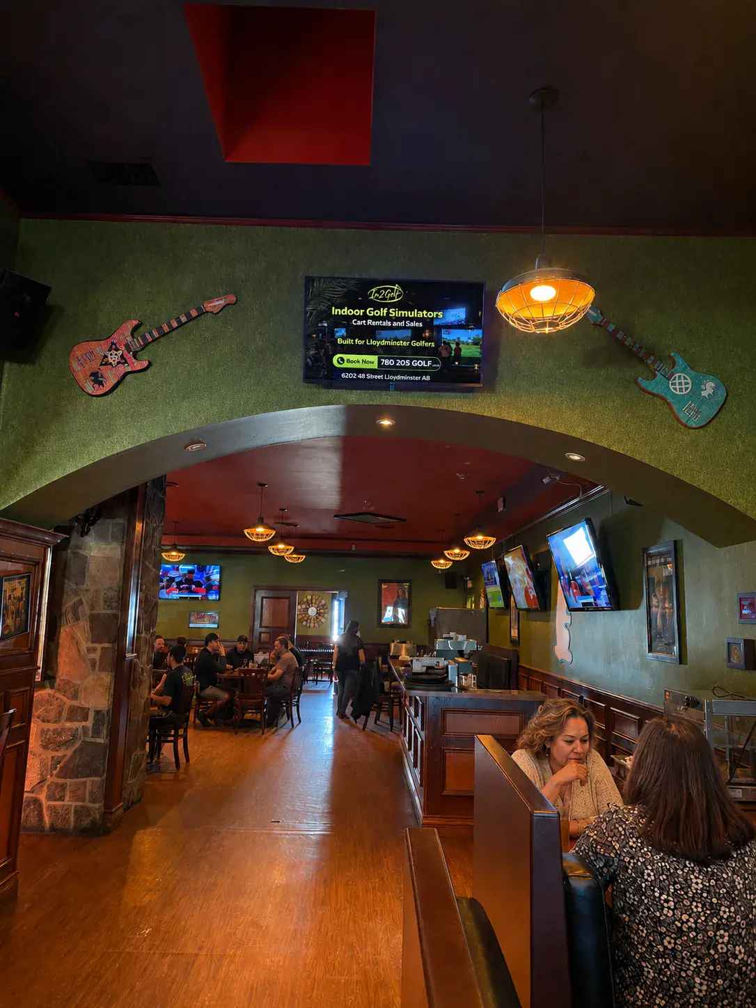 Pub and Grill — diners at the bar with the screen above